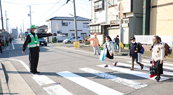 　青パト運転手の阿部幹雄さん(下写真で緑のベスト着用)は、登校時の見守りにも熱心に取り組んでいて、日和山小学校の児童からは「あべちゃん」の愛称で親しまれています