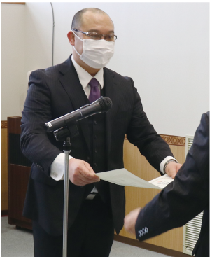 優秀指導者賞の齋藤佑さん(白根第一中学校)が表彰され、表彰状を受け取っている様子の写真