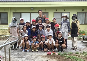 「しなの園」の園庭に花植えをした庄瀬小学校4年生の集合写真