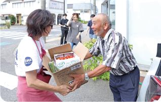 生産者から野菜を受け取っている写真